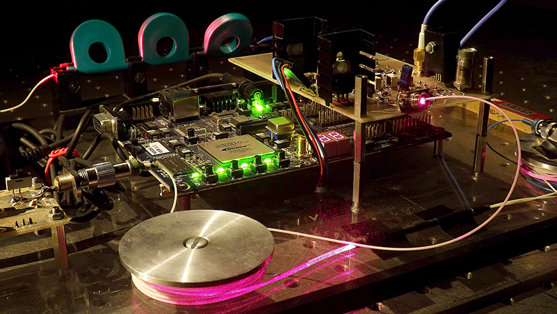 Les oscillateurs optoélectroniques (OEO) comportent une partie optique et une partie électronique, reliées entre elles via une architecture à boucle fermée comprenant un retard. Cette configuration provoque de nombreux types d’instabilités, sous la forme de fluctuations ou des oscillations des grandeurs internes optiques et électroniques. Elle a ainsi pour intérêt de produire, de manière très précisément contrôlée, des oscillations complexes avec des fréquences potentiellement très élevées, supérieures au gigahertz. Un OEO peut rester stable, générer des oscillations périodiques, multipériodiques ou même complètement chaotiques. Des chercheurs de l’institut FEMTO-ST (CNRS/Université Bourgogne-Franche-Comté) et de l’université du Maryland, très impliqués dans ces recherches, ont rédigé une synthèse de l’état de l’art sur ces objets méconnus, mais à très fort potentiel scientifique et technologique. D’abord cantonnés à l’état d’objets théoriques, les OEO ont en effet trouvé de plus en plus d’applications. Ils permettent d’étudier des phénomènes variés et complexes, avec un excellent degré de cohérence entre les résultats théoriques et expérimentaux. Les auteurs démontrent ainsi la viabilité d’applications des OEO comme la cryptographie par le chaos ou des processeurs d’intelligence artificielle, qui émulent certaines propriétés d’un réseau de neurones artificiels.